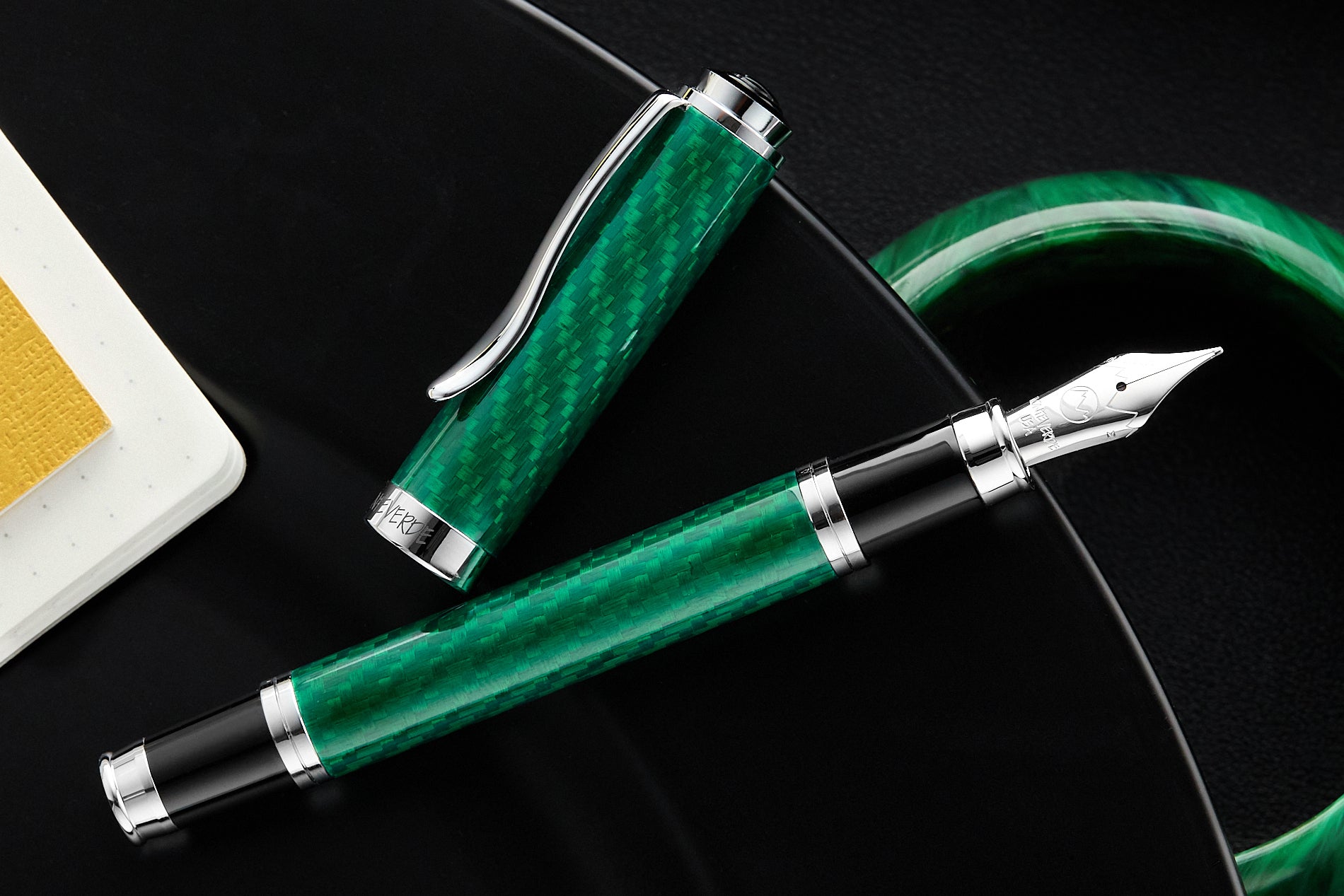 Monteverde Emerald Fiberglass fountain pen uncapped on black mirrored desktop